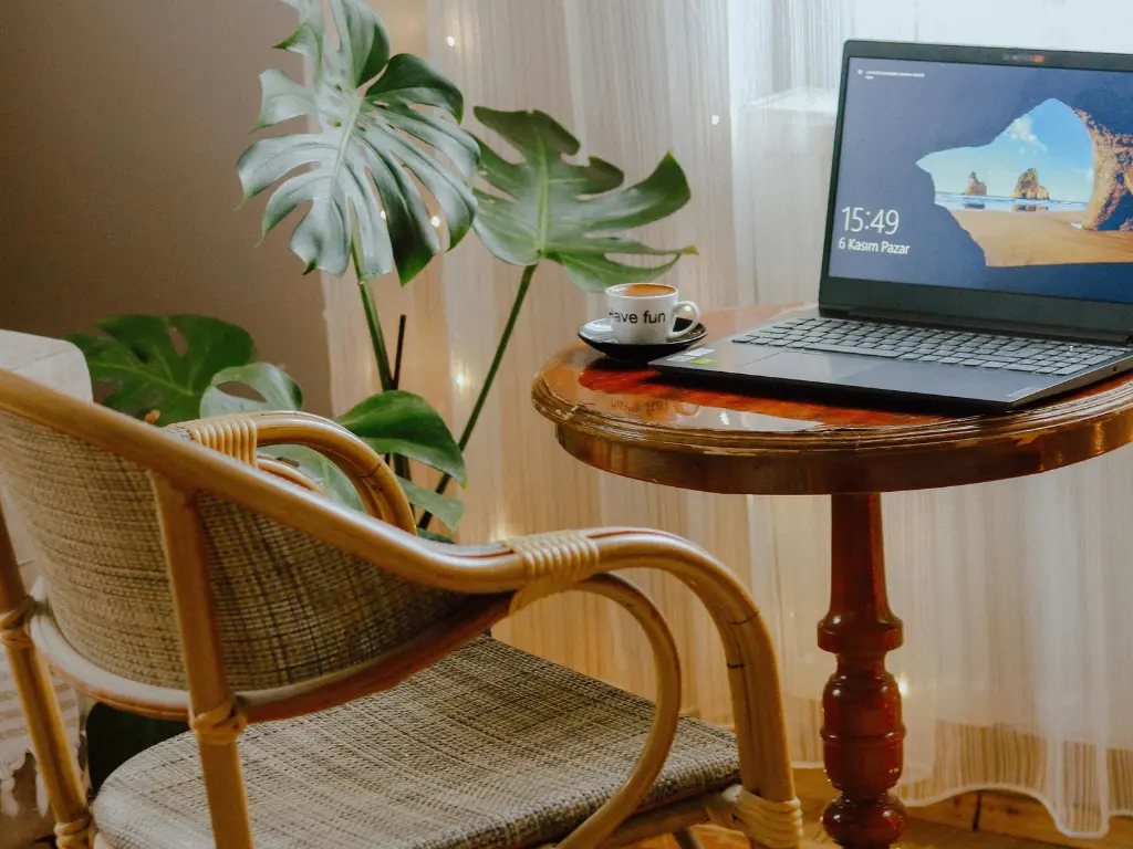 Digitoimistolla pöydällä läppäri ja kahvikuppi.